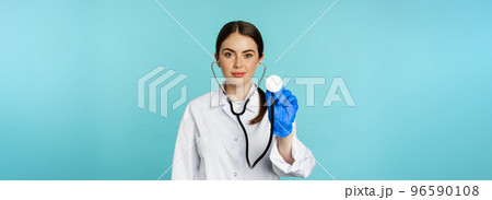 Image of woman doctor, listening patient lungs with stethoscope, doing medical checkup in clinic, standing over blue background 96590108