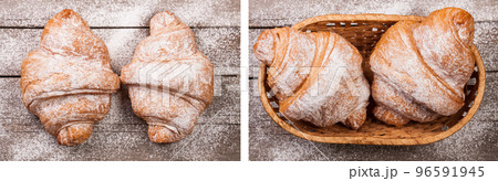 two croissants sprinkled with powdered sugar on old wooden board Top view two croissants sprinkled with powdered sugar on old wooden board Top view 96591945