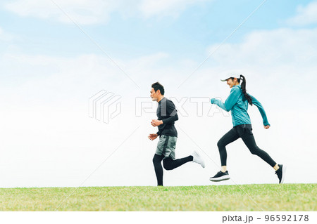 青空の見える公園でランニングするスポーツウェアを着たアジア人の男女(走る) 青空の見える公園でランニングするスポーツウェアを着たアジア人の男女(走る) 96592178