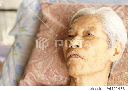 介護ベッドに横たわる認知症の高齢女性 介護ベッドに横たわる認知症の高齢女性 96595488