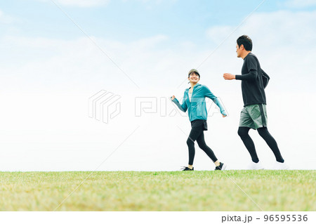 公園で話しながらランニング・ジョギング・トレーニングするスポーツウェアを着たアジア人の男女（話す） 96595536