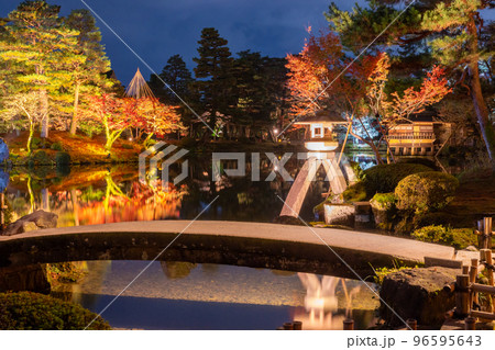 晩秋の紅葉とライトアップされた兼六園のシンボルことじ灯篭の夜景｜石川県金沢市 96595643
