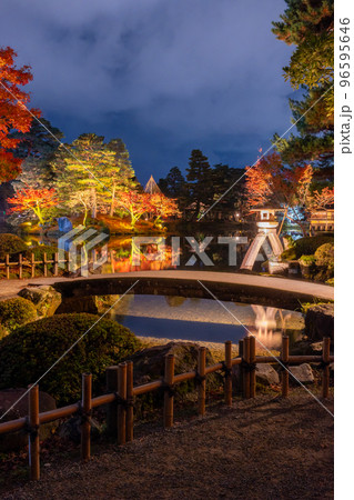 晩秋の紅葉とライトアップされた兼六園のシンボルことじ灯篭の夜景｜石川県金沢市 96595646