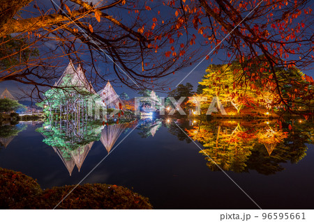 晩秋の紅葉と冬の風物詩雪吊りが兼六園の霞ヶ池に美しく反射する夜景｜石川県金沢市 96595661
