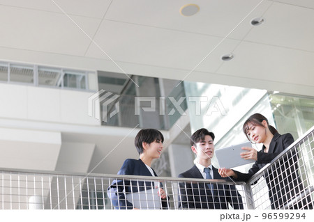 タブレットを見ながら打ち合わせる3人のビジネスパーソン_1 タブレットを見ながら打ち合わせる3人のビジネスパーソン_1 96599294