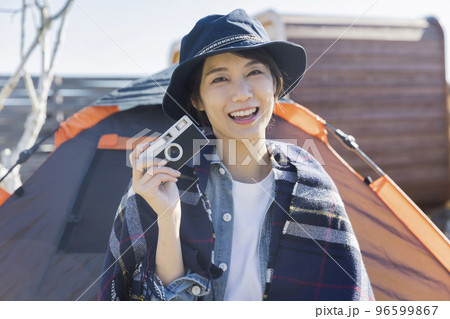 キャンプでフィルムカメラを持つ若い女性 キャンプでフィルムカメラを持つ若い女性 96599867