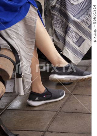 ベンチで寛ぐ女性の足元 96601814