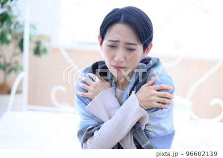 ちょっと風邪ひいたいかな~と寒がる女性 青色系(黄色系もあり)コピースペースあり ちょっと風邪ひいたいかな~と寒がる女性 青色系(黄色系もあり)コピースペースあり 96602139