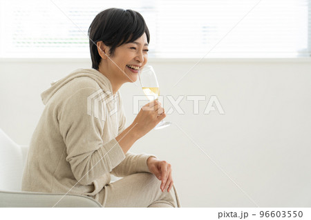 部屋でシャンパンを飲む女性 96603550