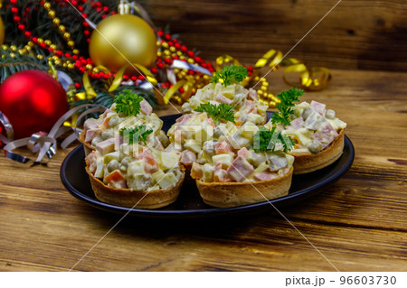 Traditional Russian festive salad Olivier in tartlets and Christmas decorations on wooden table Traditional Russian festive salad Olivier in tartlets and Christmas decorations on wooden table 96603730