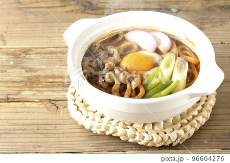 牛肉、しめじ、長葱、カマボコ、卵黄が入っている熱々味噌煮込みうどん 牛肉、しめじ、長葱、カマボコ、卵黄が入っている熱々味噌煮込みうどん 96604276