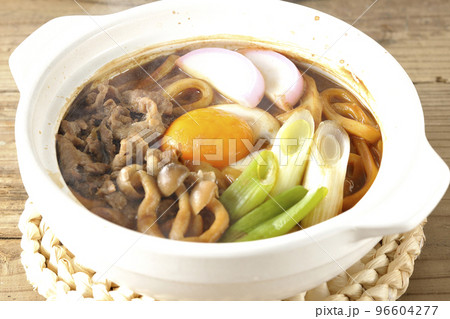 牛肉、しめじ、長葱、カマボコ、卵黄が入っている熱々味噌煮込みうどん 牛肉、しめじ、長葱、カマボコ、卵黄が入っている熱々味噌煮込みうどん 96604277