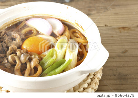 牛肉、しめじ、長葱、カマボコ、卵黄が入っている熱々味噌煮込みうどん 牛肉、しめじ、長葱、カマボコ、卵黄が入っている熱々味噌煮込みうどん 96604279