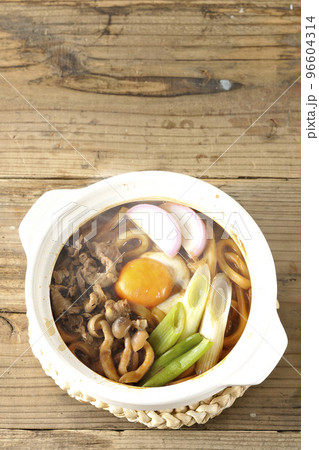 牛肉、しめじ、長葱、カマボコ、卵黄が入っている熱々味噌煮込みうどんを俯瞰で撮影 牛肉、しめじ、長葱、カマボコ、卵黄が入っている熱々味噌煮込みうどんを俯瞰で撮影 96604314