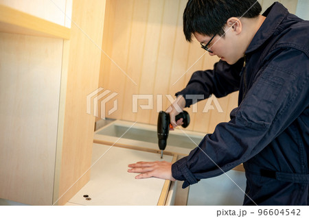 Asian male furniture assembler installing kitchen counter Asian male furniture assembler installing kitchen counter 96604542