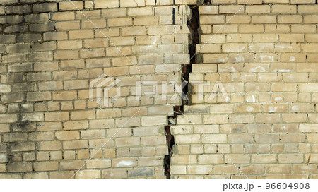 white brick wall with a large crack after an earthquake, texture backgrounds white brick wall with a large crack after an earthquake, texture backgrounds 96604908