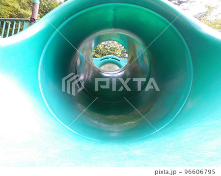 公園の緑色プラスチック製トンネル遊具の内側と中央の奥に見える出口 96606795