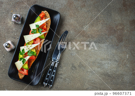 Traditional Spanish breakfast. Tostada with different toppings on a dark background. Top view with copy space 96607371