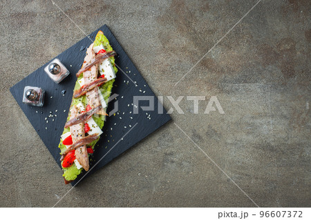 Traditional Spanish breakfast. Tostada with different toppings on a dark background. Top view with copy space Traditional Spanish breakfast. Tostada with different toppings on a dark background. Top view with copy space 96607372