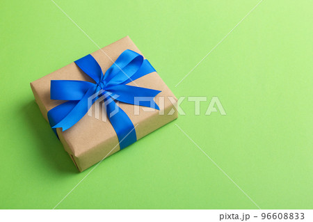 Wrapped christmas or other holiday handmade present in craft paper with colored ribbon. Present box, decoration of gift on table, top view with copy space 96608833