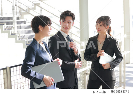 階段近くで打ち合わせる3人のビジネスパーソン_2 階段近くで打ち合わせる3人のビジネスパーソン_2 96608875