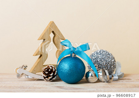 Christmas ball with decorative wooden tree on colored background. decoration bauble with ribbon bow with copy space 96608917