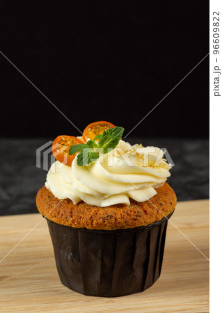 Cupcakes with cheese cream decorated with berries on dark background 96609822