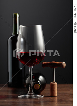 Red wine and corkscrew on a wooden table. Red wine and corkscrew on a wooden table. 96610242