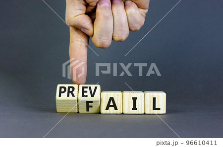 Prevail or fail symbol. Concept words Prevail or Fail on wooden cubes. Businessman hand. Beautiful grey table grey background. Business prevail or fail concept. Copy space. 96610411