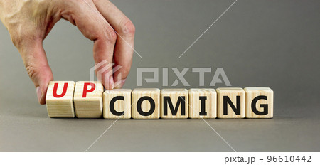 Coming or upcoming symbol. Concept words Coming and Upcoming on wooden cubes. Businessman hand. Beautiful grey table grey background. Business coming or upcoming concept. Copy space. 96610442