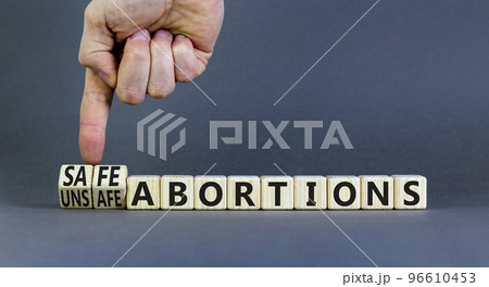 Safe or unsfe abortions symbol. Concept words Safe abortions and Unsfe abortions on wooden cubes. Doctor hand. Beautiful grey background. Medical safe or unsfe abortions concept. Copy space. 96610453