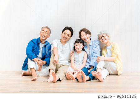 子どもを囲んで座る三世代ファミリー 96611125