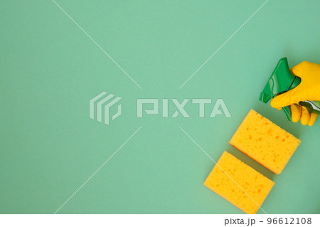Hand in yellow rubber protective glove with sponges and detergents in spray, copy space. Service concept. Top view. Flat lay. Hand in yellow rubber protective glove with sponges and detergents in spray, copy space. Service concept. Top view. Flat lay. 96612108