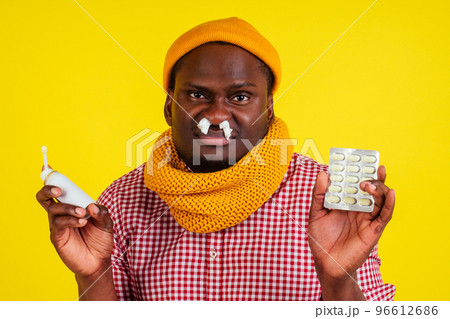 young african american male wearing red checkered shirt with knitted scarf and hat feeling bad unwell with fever heat and chills in studio yellow background.flu and virus concept young african american male wearing red checkered shirt with knitted scarf and hat feeling bad unwell with fever heat and chills in studio yellow background.flu and virus concept 96612686