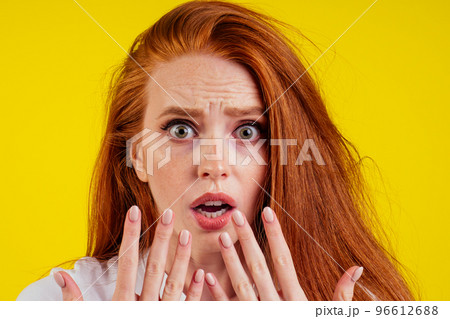 ungroomed nervous unhappy young redhaired ginger woman looking at a broken fingernail and crying .nude manicure in studio yellow background.dry and split ends of hair ungroomed nervous unhappy young redhaired ginger woman looking at a broken fingernail and crying .nude manicure in studio yellow background.dry and split ends of hair 96612688