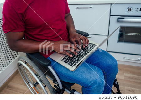 african american man in wheelchair with laptop at kichen african american man in wheelchair with laptop at kichen 96612690