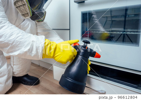 pest control worker standing with sprayer in kitchen pest control worker standing with sprayer in kitchen 96612804