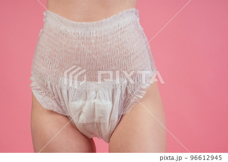 young redhaired ginger woman wearing incontinence diaper in studio pink background 96612945