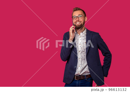 Studio shot of attractive brunette business man with glasses, in casual shirt, stylish black jacket talking on the cell phone and smiling. Studio shot of attractive brunette business man with glasses, in casual shirt, stylish black jacket talking on the cell phone and smiling. 96613132