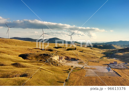 Drone view of power stations for renewable electric energy production. Windmills on sunny summer day. High wind turbines for generation electricity. Drone view of power stations for renewable electric energy production. Windmills on sunny summer day. High wind turbines for generation electricity. 96613376