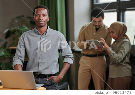 Young confident business leader in smart casualwear standing by workplace 96613478