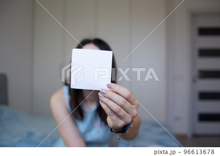 Woman holding sheet of white paper for your text Woman holding sheet of white paper for your text 96613678