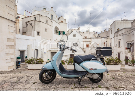 View of the old town of Martina Franca. Classic blue moped on the background of an anient buildings. 96613920