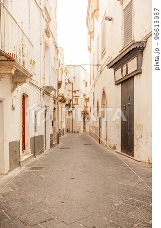 View of the old town of Martina Franca with a beautiful houses painted in white. View of the old town of Martina Franca with a beautiful houses painted in white. 96613937