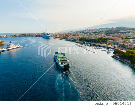Messina, Sicily, Italy, August 20, 2022. Ferry that transports cars and passengers from one side to the other of the Strait of Messina between Calabria and Sicily. Aerial view. 96614212