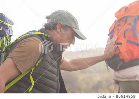 Elderly man hiking on cloudy day 96614859