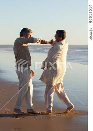 Romantic senior couple spending time at seashore at sunset 96615014