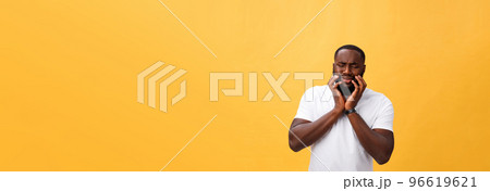 Young Stressed man with hand on his face showing sadness and despair. Isolated over yellow background. 96619621