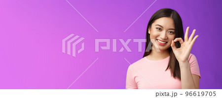 Cute smiling asian girl approve good plan, show okay ok sign, tilt head lovely grinning, satisfied perfect quality product, give positive feedback, accept choice, stand purple background 96619705
