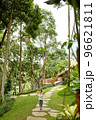 A slender girl walks along a stone path in a tropical garden on the island of Bali 96621811